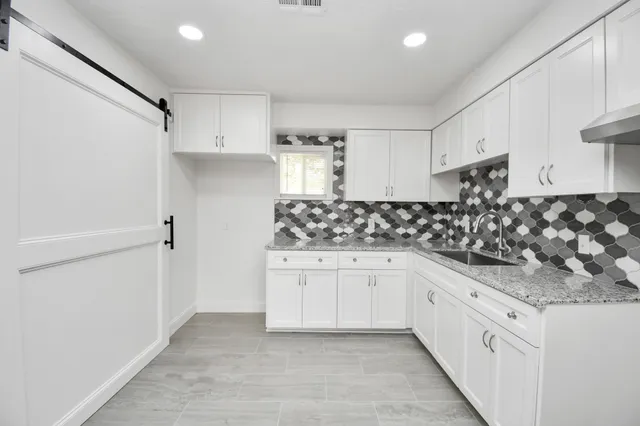 a kitchen with granite countertop white cabinets and white appliances