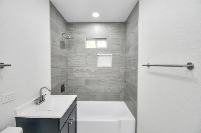 a bathroom with a sink a mirror and a bathtub