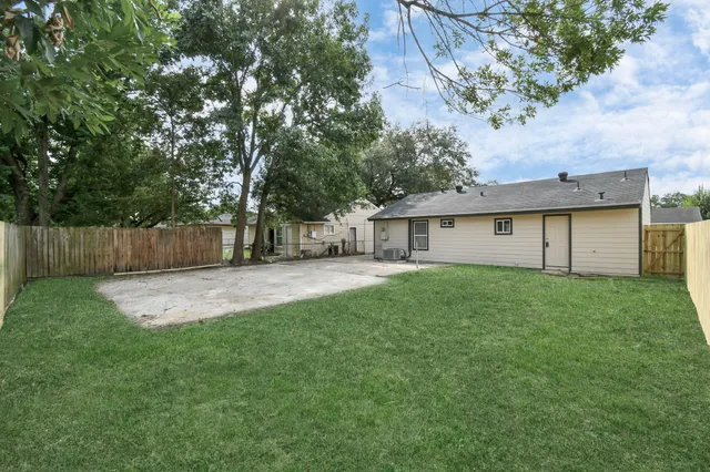 a view of a yard with a house and a large tree