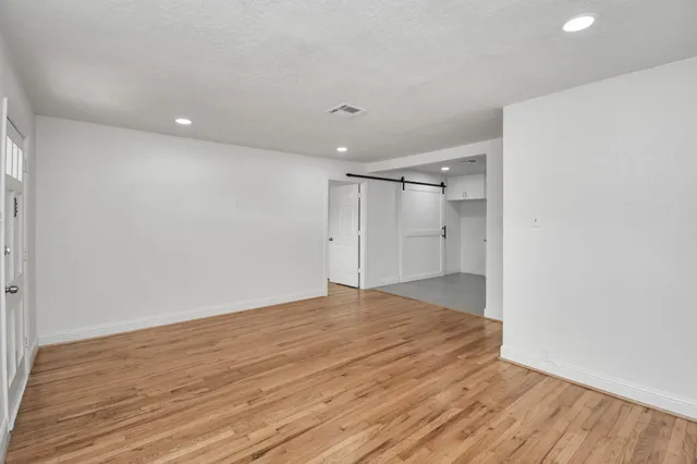 a big room with wooden floor and natural light