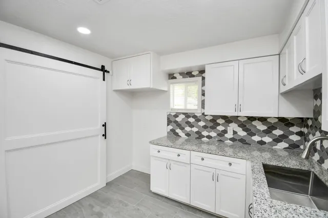 a kitchen with white cabinets and white appliances
