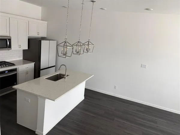 a kitchen with a sink cabinets and wooden floor