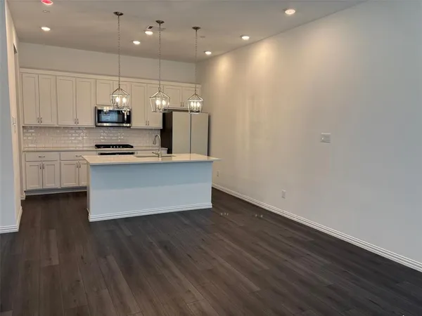 a kitchen with kitchen island a stove a sink and a refrigerator