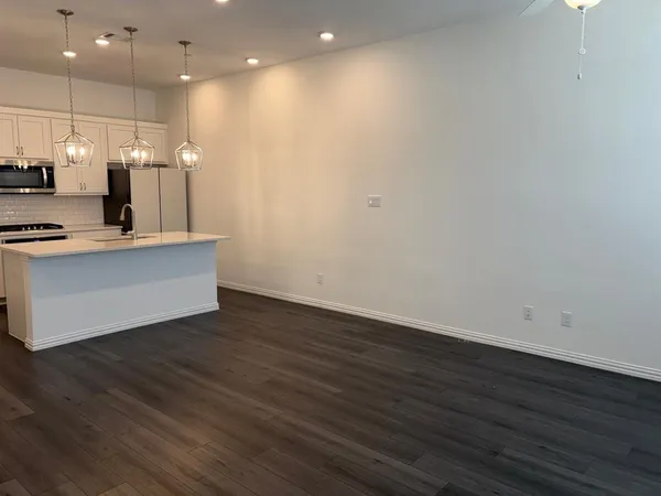 a view of kitchen with cabinets appliances and wooden floor