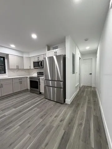 a kitchen with stainless steel appliances a refrigerator sink and microwave
