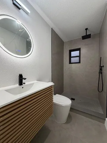 a bathroom with a sink a toilet and a mirror