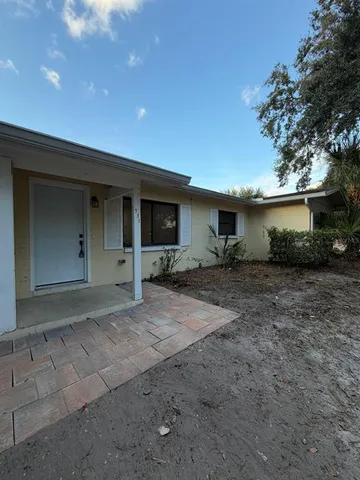 a view of a house with backyard space and a tree
