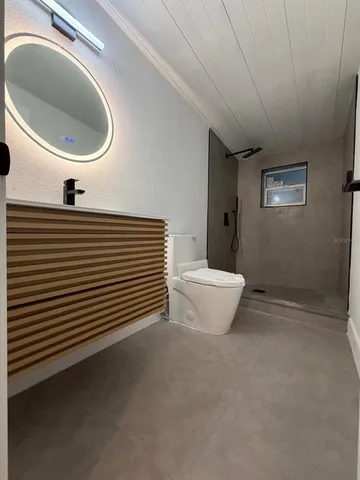 a bathroom with a toilet a sink and mirror
