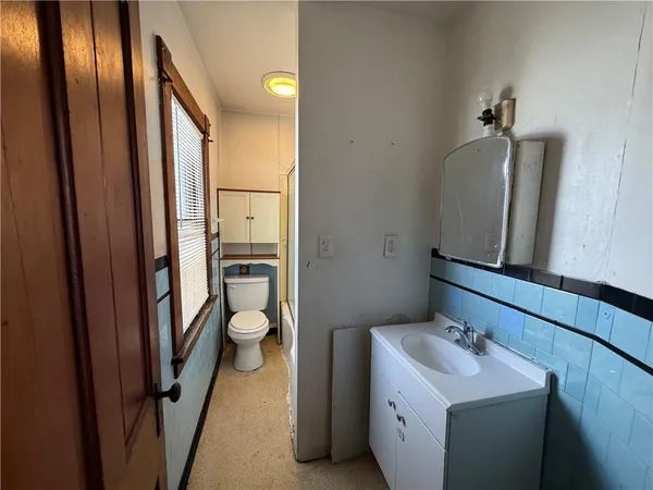 a bathroom with a toilet sink and mirror