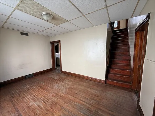 a view of an empty room with wooden floor