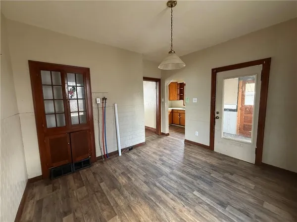 a view of empty room with wooden floor and window