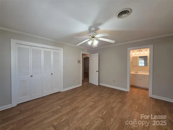 a view of an empty room with a chandelier fan