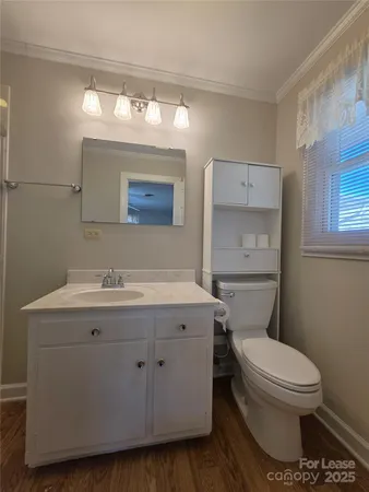 a bathroom with a granite countertop toilet sink and mirror