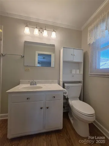 a bathroom with a granite countertop toilet sink and mirror