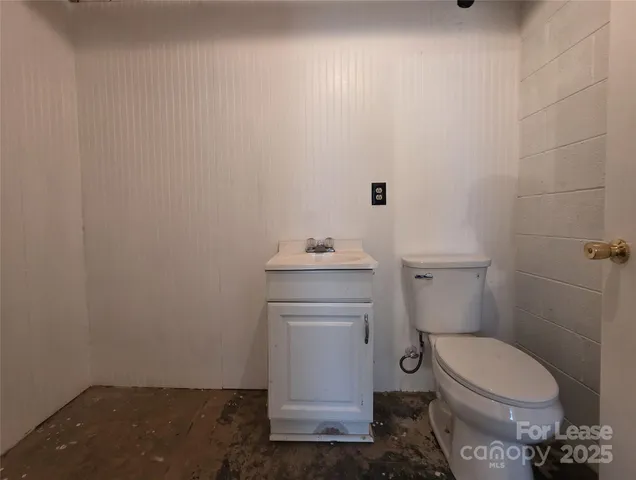 a bathroom with a toilet a sink and mirror