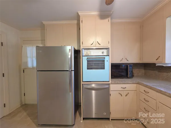 a white refrigerator freezer and a stove sitting inside of a kitchen
