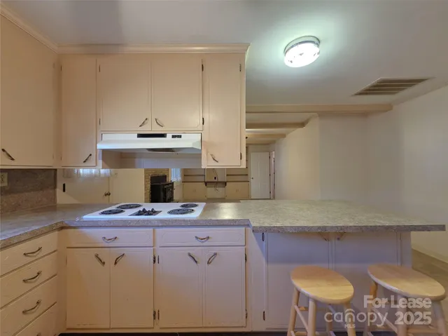 a kitchen with cabinets and wooden floor