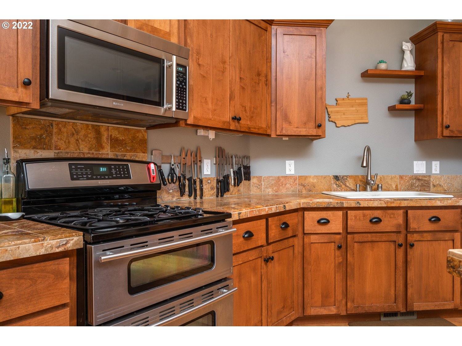 686 Eufaula Heights Road Longview, WA 98632 - Photo 9 of 29 a kitchen with granite countertop a stove top oven microwave and cabinets