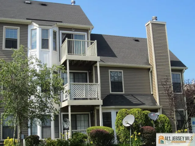 a front view of a house with garden and plants
