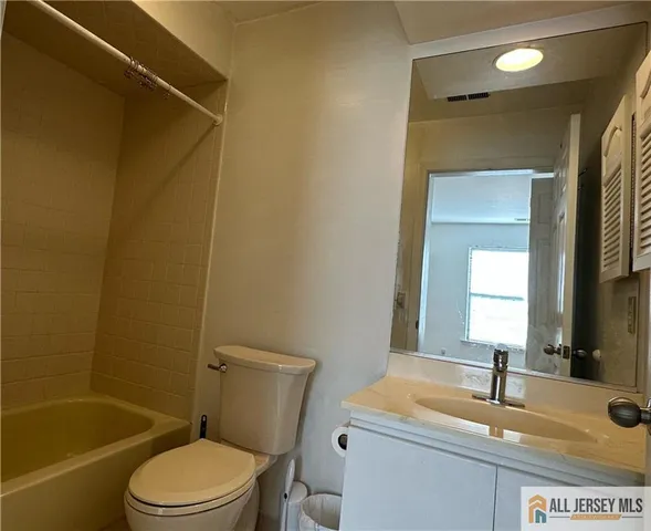 a bathroom with a granite countertop sink toilet tub and shower