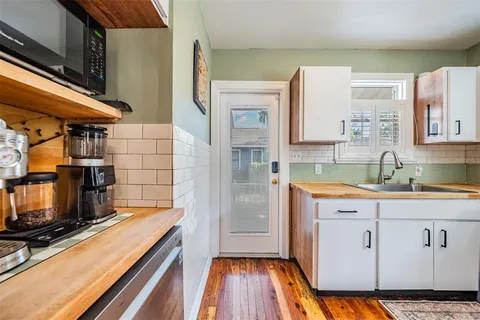 a kitchen with kitchen island a counter top space a sink stainless steel appliances and cabinets