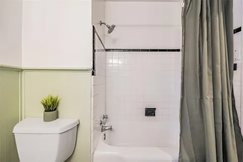 a bathroom with a shower a toilet and a sink