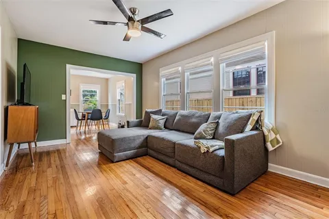 a living room with furniture and a wooden floor