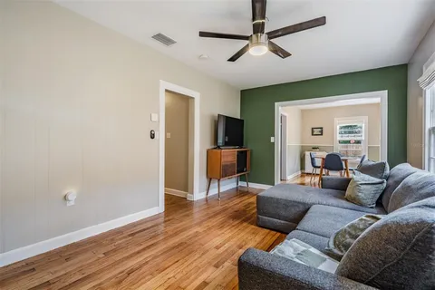 a living room with furniture and a wooden floor
