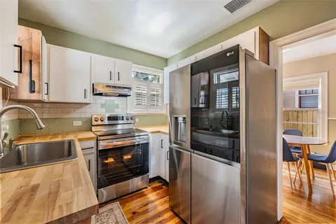 a kitchen with stainless steel appliances granite countertop a refrigerator and a stove top oven