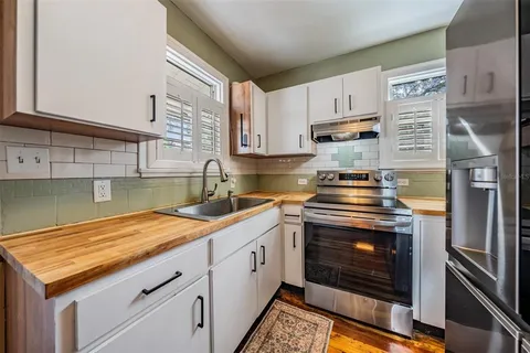a kitchen with granite countertop a sink stainless steel appliances and cabinets
