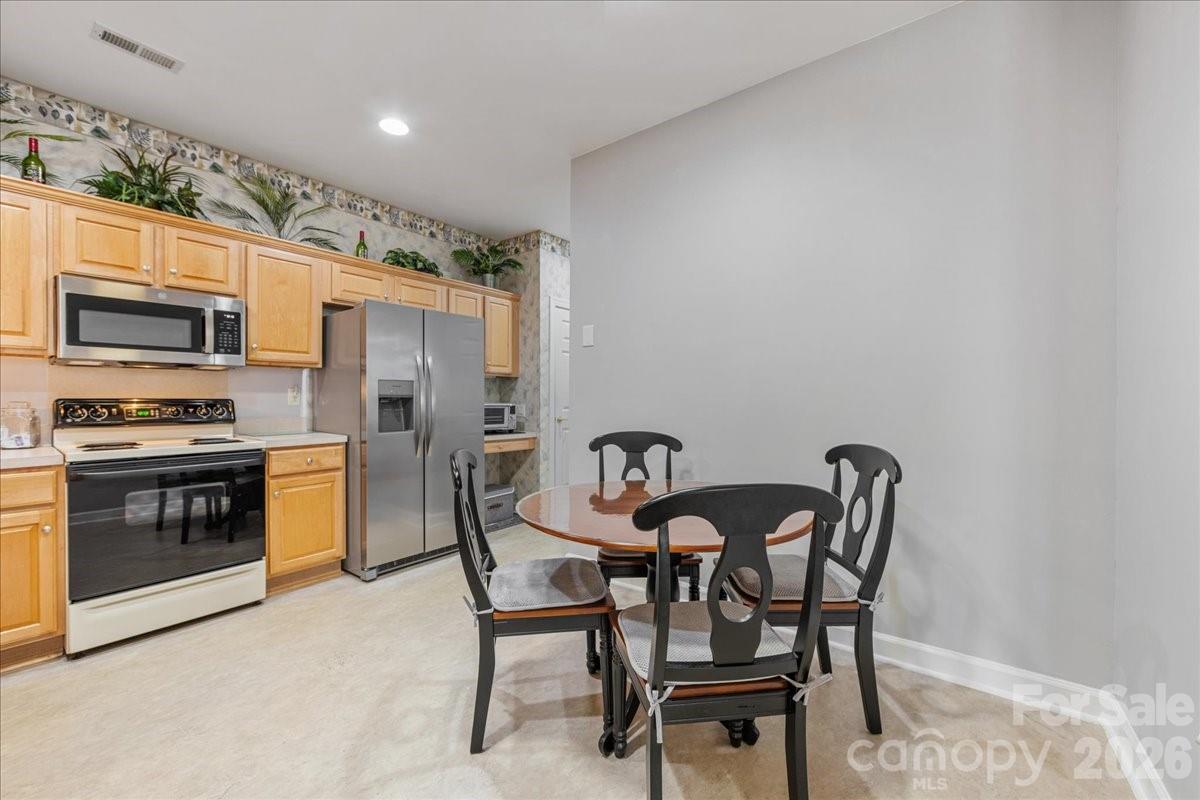 8368 Windsor Ridge Drive Charlotte, NC 28277 - Photo 22 of 46 a kitchen with stainless steel appliances kitchen island granite countertop a dining table and chairs