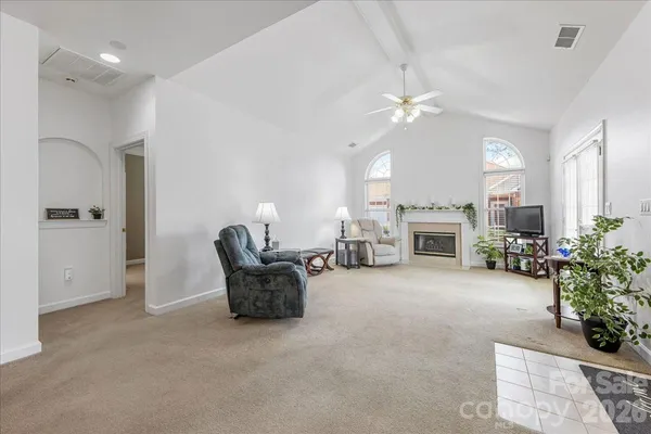 a living room with furniture a fireplace and a chandelier