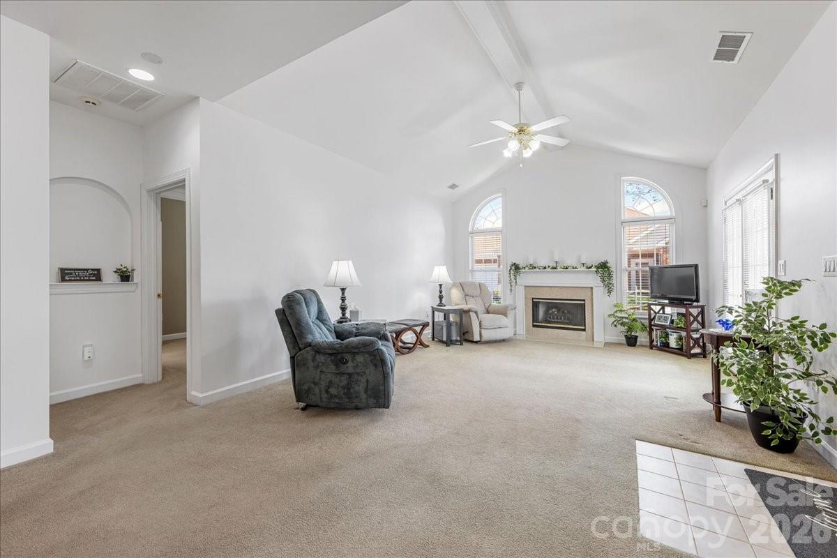 8368 Windsor Ridge Drive Charlotte, NC 28277 - Photo 3 of 46 a living room with furniture a fireplace and a chandelier