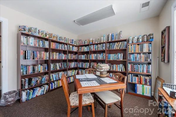a view of a work space with a book shelf and a window
