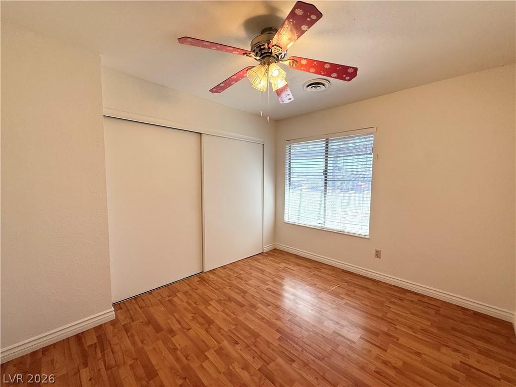616 Greenway Road Henderson, NV 89002 - Photo 26 of 32 Hardwood-style flooring and a window with blinds define this inviting space, perfect for quiet repose.