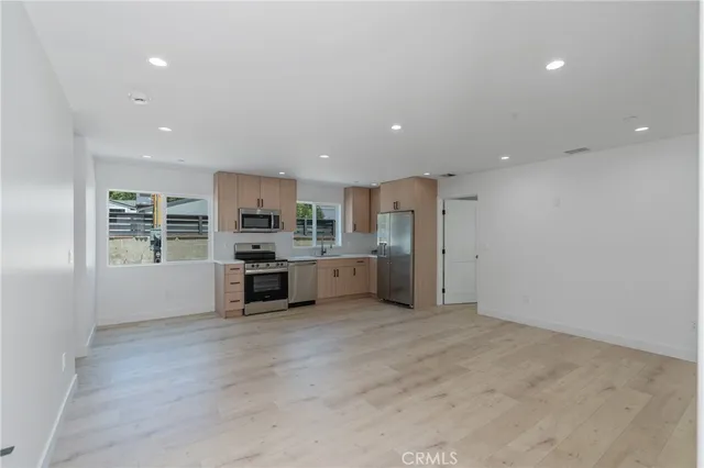 a kitchen with stainless steel appliances a refrigerator and a stove top oven