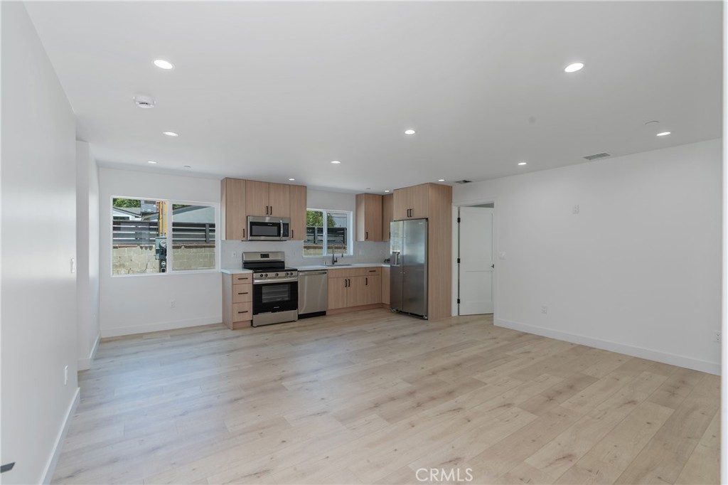 a kitchen with stainless steel appliances a refrigerator and a stove top oven