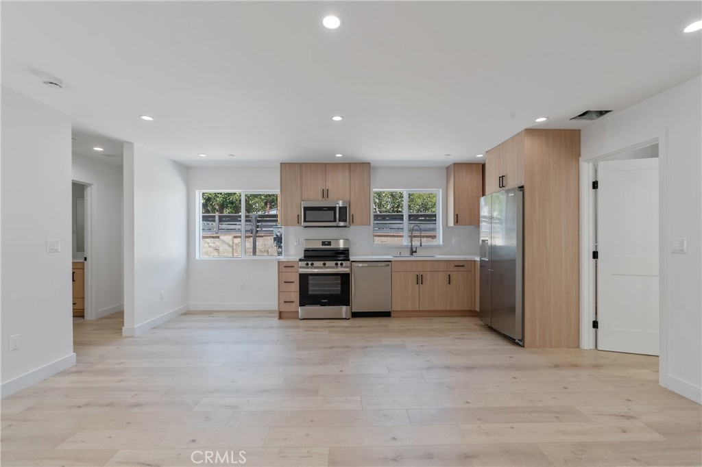 7439 Ranchito Avenue Van Nuys, CA 91405 - Photo 2 of 10 a kitchen with refrigerator a sink and cabinets