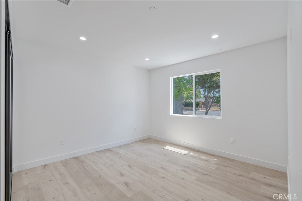 7439 Ranchito Avenue Van Nuys, CA 91405 - Photo 3 of 10 an empty room with wooden floor and windows