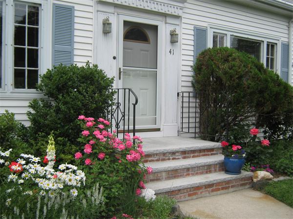 41 Longfellow Road Needham, MA 02494 - Photo 14 of 20 a front view of a house with a flower garden
