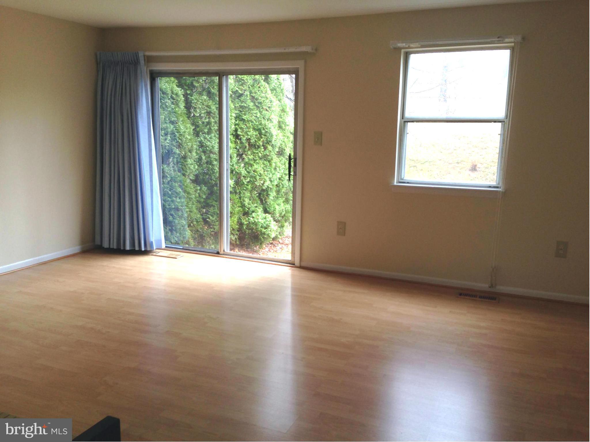 9325 Pan Ridge Road Baltimore, MD 21234 - Photo 5 of 20 an empty room with wooden floor and windows