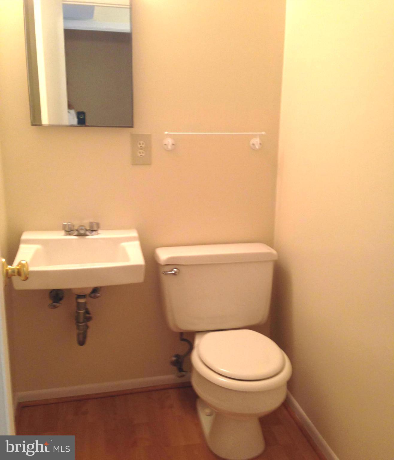 9325 Pan Ridge Road Baltimore, MD 21234 - Photo 7 of 20 a bathroom with a sink a toilet and mirror