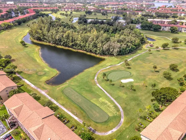 an aerial view of a house with a yard and lake view