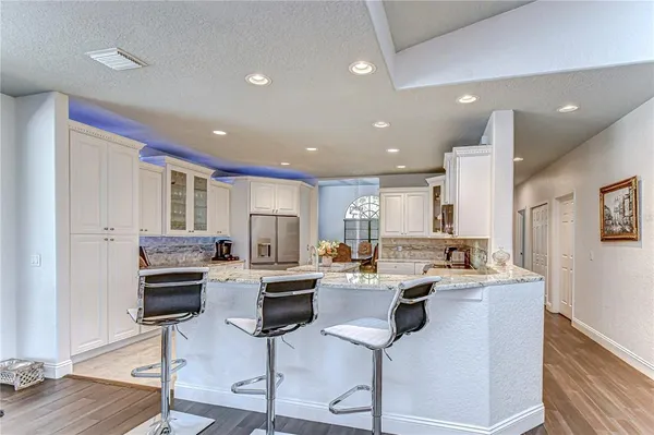 a kitchen with granite countertop cabinets stainless steel appliances a sink and a living room view