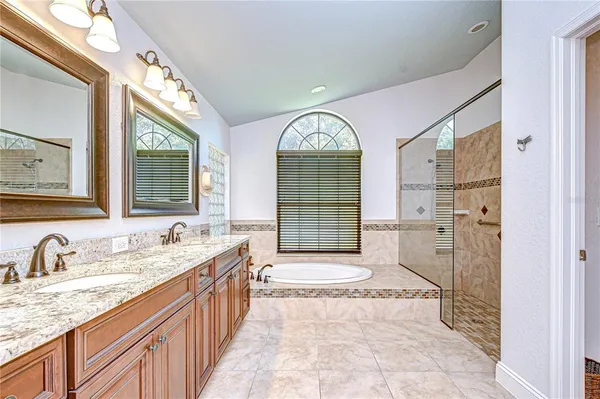 a en suite bathroom with a granite countertop double vanity and a mirror