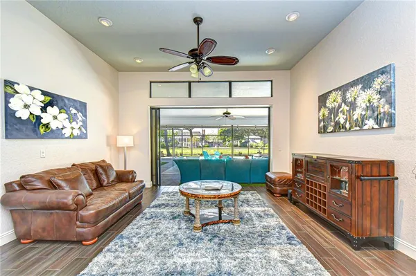 a view of a livingroom with furniture wooden floor mirror and windows