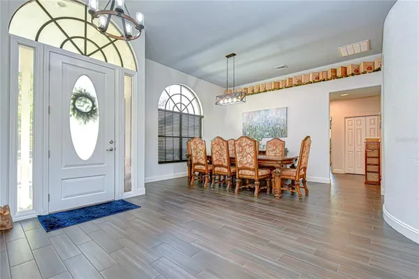 a living room with furniture a dining table and paintings on the wall