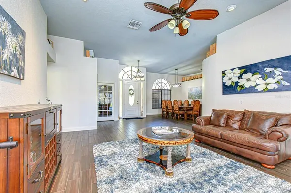 a living room with furniture a bookshelf and a window