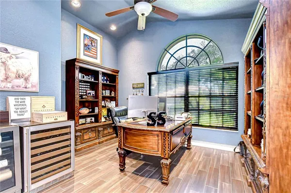 a kitchen with stainless steel appliances kitchen island granite countertop a stove a sink a refrigerator and white cabinets with wooden floor