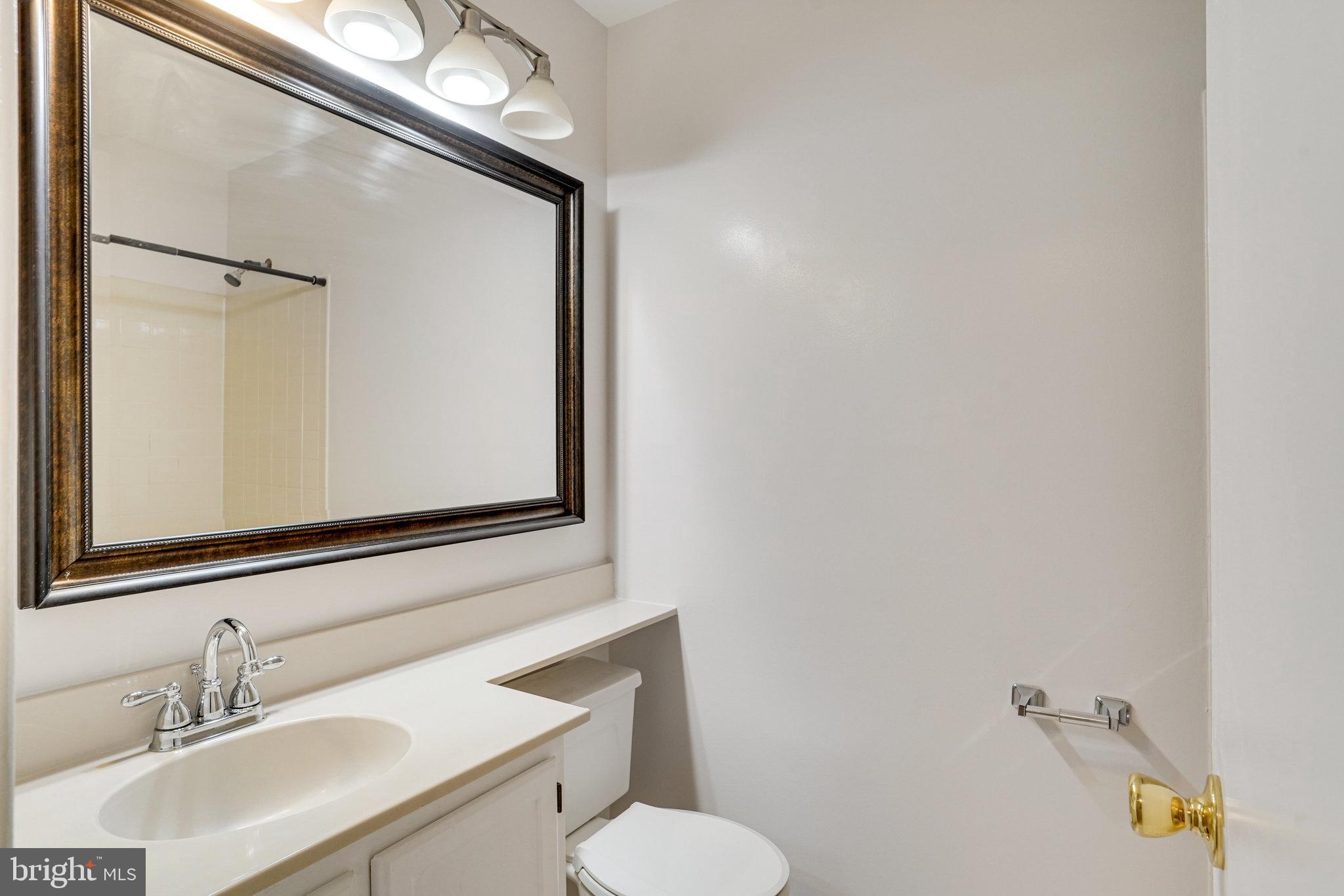 7918 Pebble Brook Court Springfield, VA 22153 - Photo 15 of 28 a bathroom with a toilet a sink and mirror